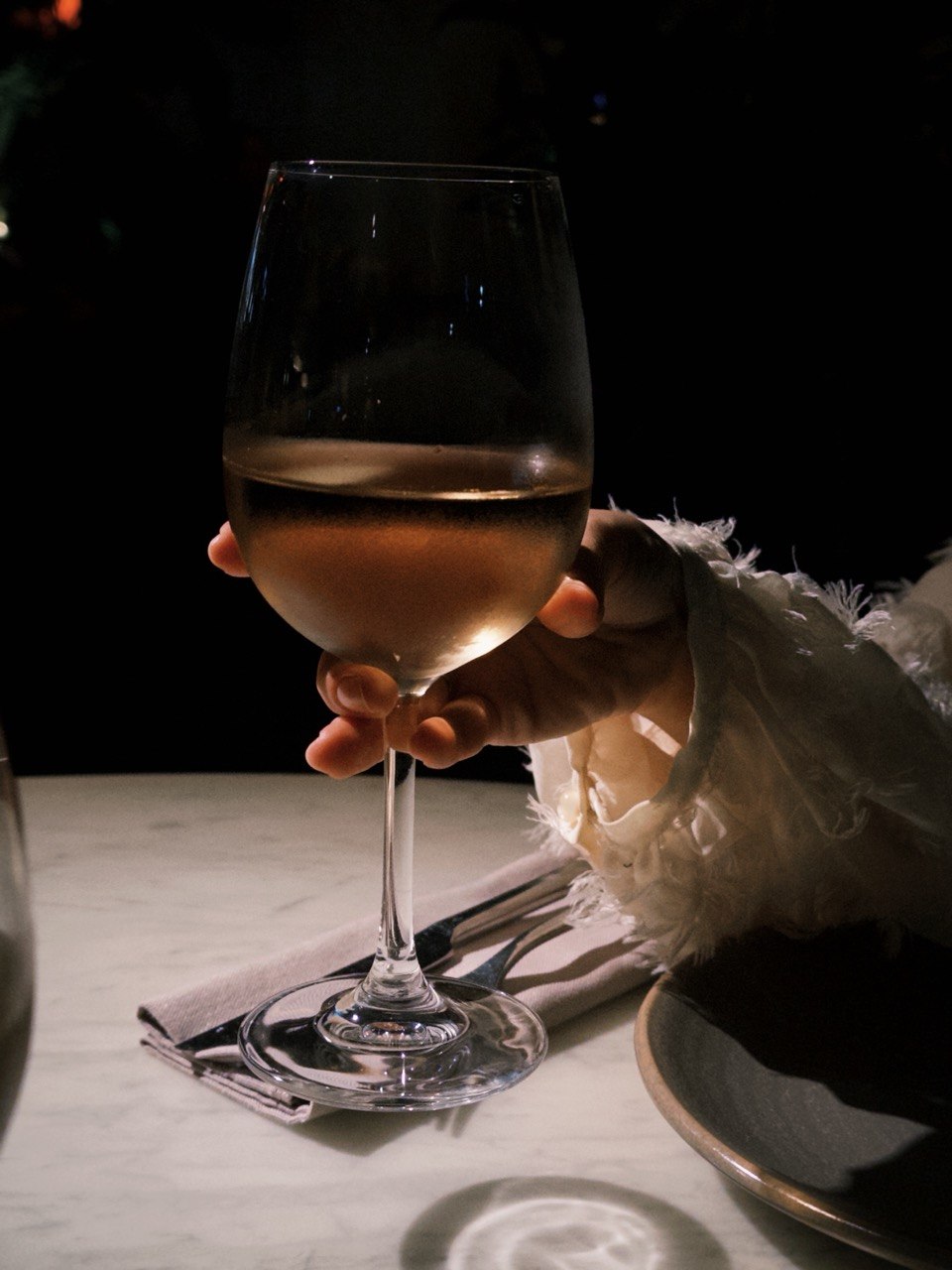 A glass of natural Georgian wine on marble at MIDI Wine Bar